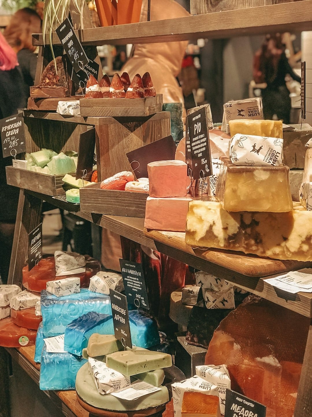 Artisanal soaps displayed on a rustic wooden shelf.